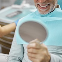Senior man admiring his smile after undergoing All-on-4 treatment