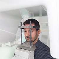 Man standing in machine during cone beam scan