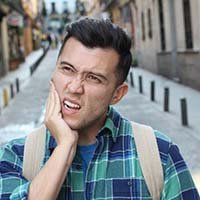 Wondering man with toothache has questions for his emergency dentist 