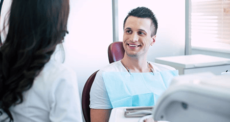 Happy patient talking with dental team member