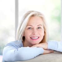 Mature woman smiling with her new dental implants in Allen