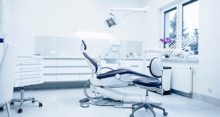 Empty dental treatment room with white walls
