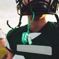 Football player with sports mouthguard hanging from his helmet