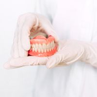 Doctor holding dentures