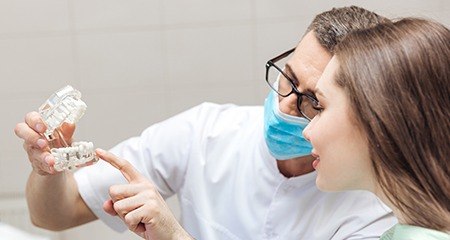 Dental team member talking to patient in consultation room
