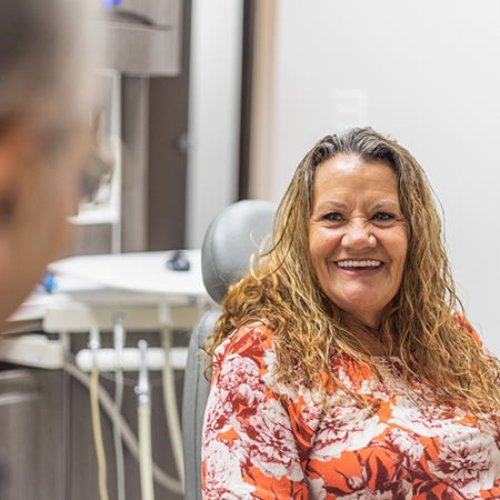 Woman in dental chair smiling at her dentist