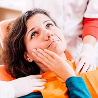 Concerned woman visiting dentist for implant salvage services