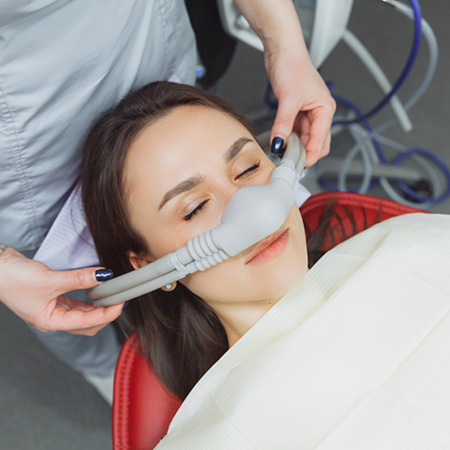 Dental patient with a nitrous oxide mask over her nose