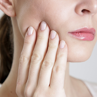 Close up of a woman holding her cheek