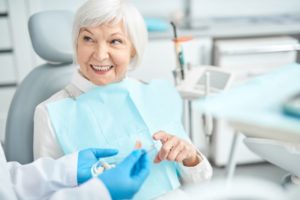 Senior patient smiling and speaking with dentist