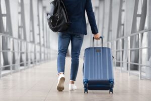 Person walking with their suitcase through the airport